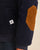 Gros plan sur la coudière camel et la poche latérale de la doudoune puffer bleu navy Côtelé Paris