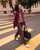 Femme marchant en extérieur avec la veste worker en velours côtelé bordeaux et un sac de voyage Côtelé Paris.